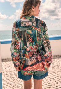 Kleurrijk, patroonhemd gemaakt van lichtgewicht stof, met bloemenmotieven, ramen en een kat, met een losse pasvorm en lange mouwen.