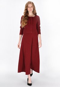 Rochie din două piese de culoare vișinie, având un cardigan scurt, mulat, cu un fes și trei nasturi, asortată cu o fustă lungă și vaporoasă.
