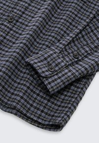 Geverifieerd button-up overhemd in marineblauw en zwart, met een zachte textuur, een puntige kraag en zwarte knopen op de manchetten.