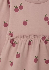 Rosa Stoff mit kleinen gedruckten roten Äpfeln und grünen Blättern, mit gerafftem Rüschendetail in der Mitte.