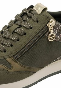 Sneaker verde oliva con pelle e tessuto testurizzati, caratterizzato da una cerniera decorativa sul lato, lacci decorati e accessori in oro.