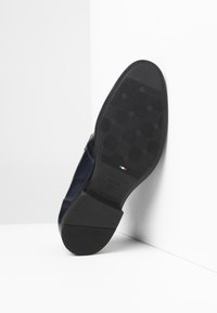 La suola della scarpa in pelle blu presenta una presa in gomma con motivo, con dettagli del marchio e della bandiera italiana. Finitura liscia con una punta arrotondata.