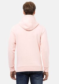 Lichtroze hoodie met een trekkoordcapuchon, ribgebreide manchetten en zoom. Zachte stof met een gladde textuur, met een eenvoudig ontwerp zonder zichtbare logo's.