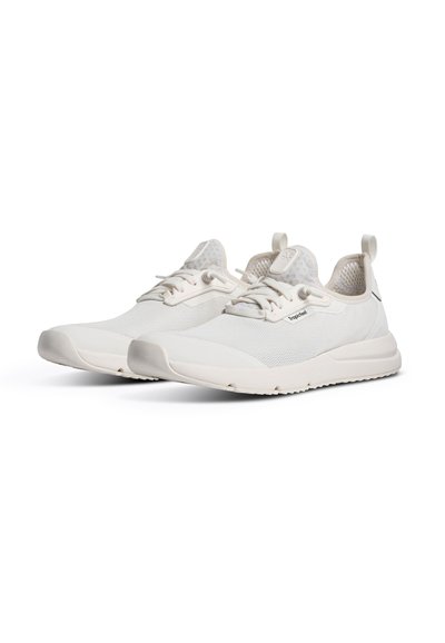Paire de baskets basses blanches avec dessus en mesh texturé, lacets et semelles épaisses et rembourrées sur fond blanc.