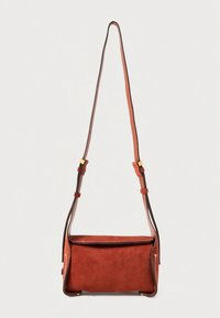 Sarkans zamšādas plecu soma ar taisnstūra formu. Aprīkota ar brūnu ādas siksnu, zelta detaļām un sānu kabatām ar rāvējslēdzējiem.