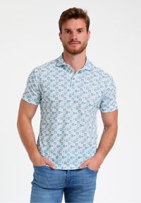 Polo majica s kratkimi rokavi v svetlo modri barvi s belim vzorcem kvadratov in ikon. Narejena iz mehkega blaga s klasičnim ovratnikom.