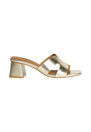 Sandalias de tacón de metal dorado con tacón cuadrado, diseño de tiras abiertas, textura suave y un cruce en la parte frontal para fácil uso.