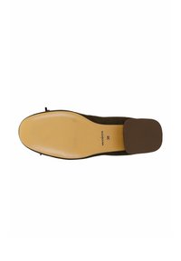 Semelle en suède marron avec une surface texturée. La chaussure présente un petit talon bloc et un design à bout arrondi, étiquetée taille 38.