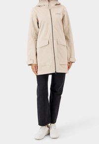 Světle béžová nepromokavá bunda se zipem vpředu, dvěma velkými kapsami a kapucí. Vyrobena z odolného materiálu, s ležérním designem.