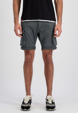 Shorts cargo gris avec ourlets repliés, plusieurs poches latérales, fabriqués en tissu léger. Portés avec des baskets noires et grises.