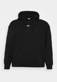 Sudadera con capucha negra hecha de una mezcla de algodón, con un bolsillo frontal, puños de canalé y un pequeño parche de logo de color en el pecho.