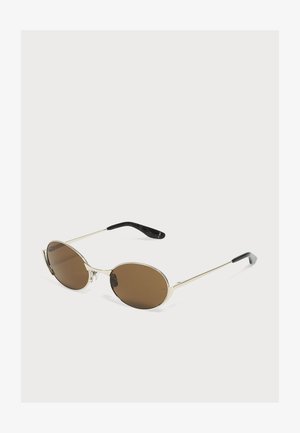 Lunettes de soleil de forme ovale avec fines montures en métal argenté et verres teintés marron, embouts en plastique noir sur les branches, présentées sur fond blanc.