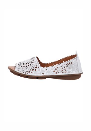 White perforated flat sandal with geometric cutouts and scalloped edges, featuring a brown cushioned insole and flexible sole.