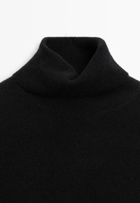 Maglione a collo alto nero realizzato in tessuto morbido con una trama a coste, dotato di un colletto ripiegato per una forma aderente.