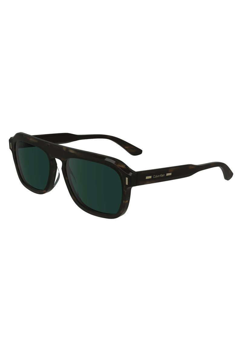 Lunettes de soleil en écaille noire avec verres vert foncé. Forme carrée, accents discrets sur les côtés et design élégant des branches, ornées du logo Calvin Klein.