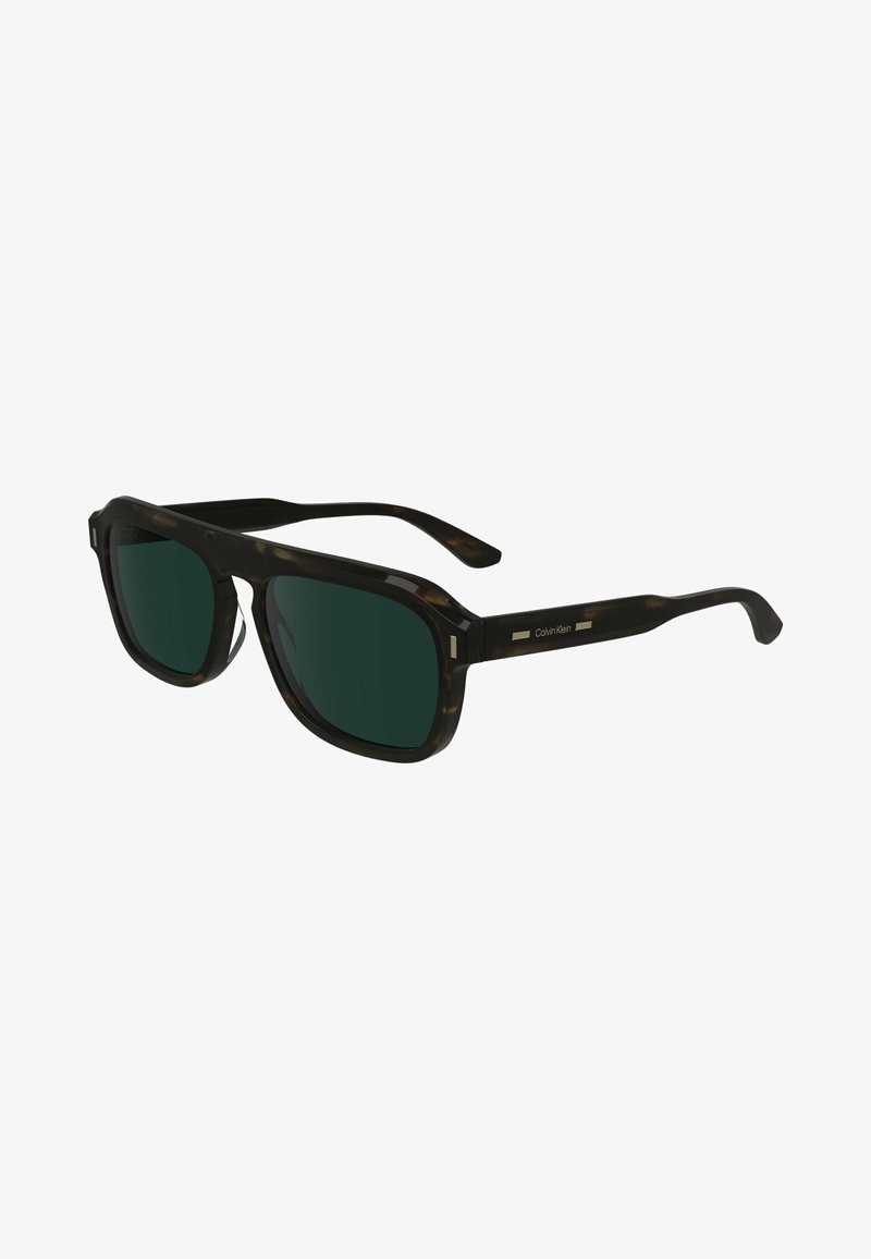 Gafas de sol de carey negro con lentes verde oscuro. Forma cuadrada, acentos laterales sutiles y un diseño de varilla elegante, marcadas con Calvin Klein.