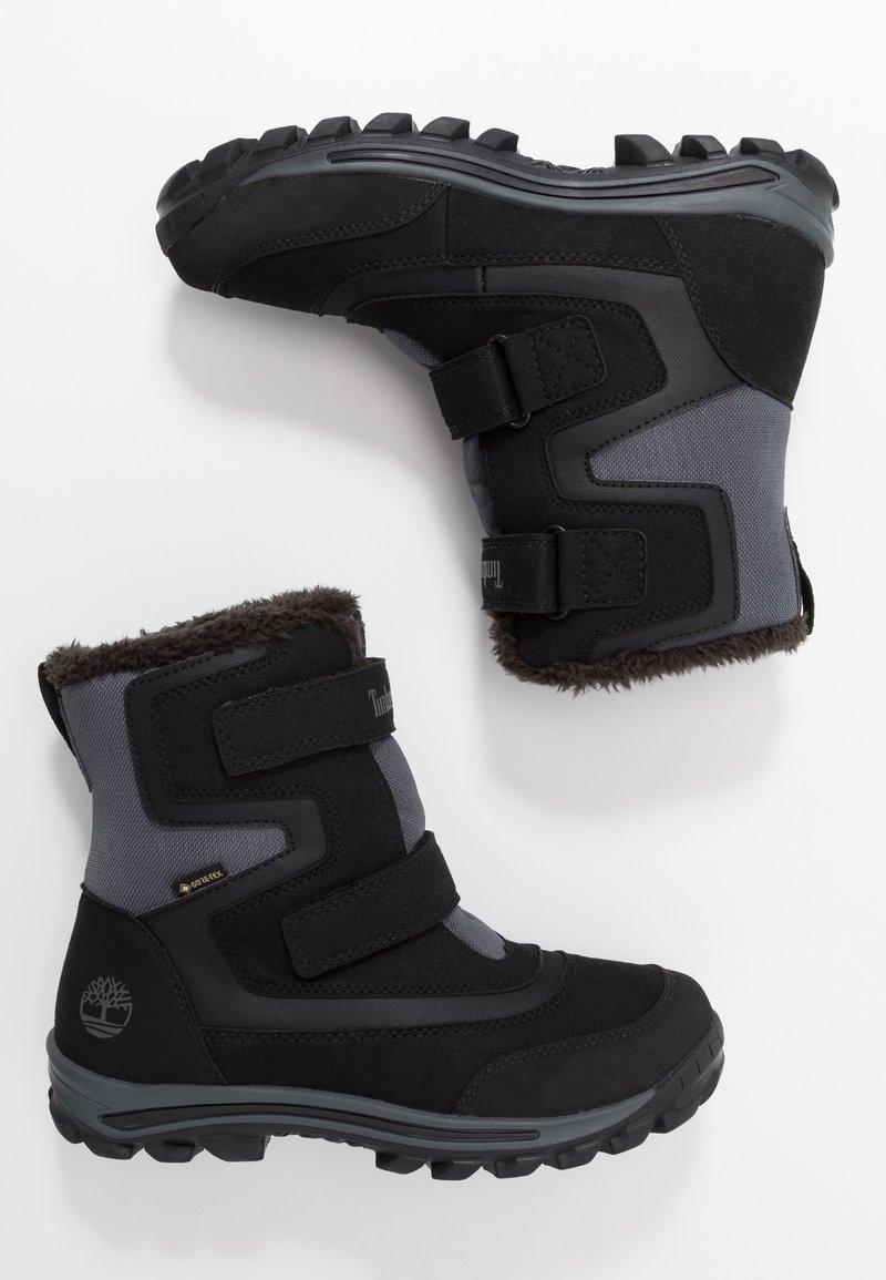 Bottes d'hiver isolées noires et grises avec des sangles Velcro, des semelles robustes et une doublure en fourrure, conçues pour le froid et une utilisation extérieure.