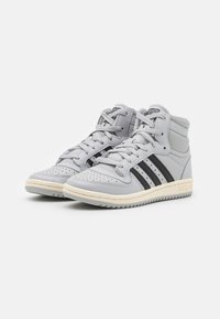 Gray high-top sneakers with a leather upper, perforated toe, three black stripes, and a beige rubber sole. Laces and tongue in matching gray.