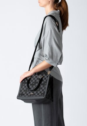 Bolso negro con estampado, equipado con dos asas y una correa de hombro desmontable. Textura suave, forma estructurada y adornos de hardware dorados.