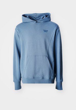 Kék kapucnis pulóver kenguruzsebbel, kerek zsinóros kapucnival, bordázott mandzsettákkal és aljjal. Elöl Reebok logó található. Simító pamut keverék anyag.
