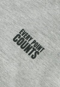 Grauer Baumwollstoff mit glatter Textur, auf dem in der Mitte des Materials der schwarze, erhabene Text "EVERY POINT COUNTS" zu sehen ist.