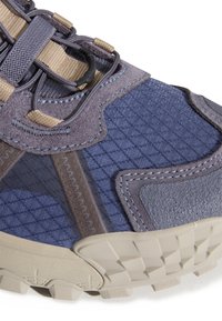 Niebiesko-szare tenisówki z teksturowaną cholewką z zamszu i nylonu, wyposażone w wyściełany kołnierz, misterny szew oraz trwałą, gumową podeszwę.