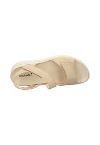 Beige Sandale mit Riemen aus weichem Wildledermaterial. Verfügt über eine gepolsterte Innensohle und eine weiße Gummisohle, die für Komfort und Unterstützung sorgt.