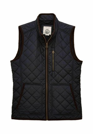 Navy sininen tilkkutäkki ilman hiuksia liivi ruskeilla korostuksilla, etuvetoketju, kaksi ala-taskua ja yksi vetoketjullinen rintatasku.