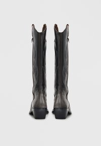 Tall black leather cowboy boots with a pointed toe, decorative stitching, and a slight heel; features pull tabs for easy wear.