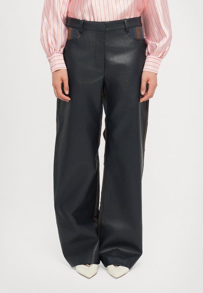 Pantalons larges noirs en simili cuir avec coutures latérales. Présentent des coutures contrastées et une texture lisse et raffinée.