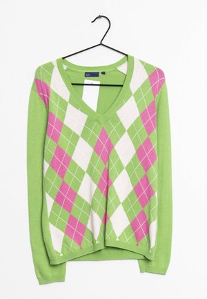 Maglione a V in verde con motivo a diamante in rosa e bianco. Caratterizzato da una texture lavorata a maglia e maniche lunghe. Appeso a un gancio nero.