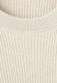 Beige gebreide trui met een geribbelde textuur en een brede ronde hals. De stof lijkt zacht en enigszins dik.