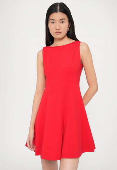 Punane varrukateta kleit, millel on keha järgiv ülakeha ja lehvikukujuline seelikuosa. Valmistatud siledast kangast, ümmarguse kaeluse ja küljetaskutega.