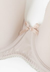 Sostenitore beige imbottito con finitura liscia, caratterizzato da un delicato bordo in pizzo e un piccolo dettaglio in raso a fiocco al centro per un tocco di eleganza.