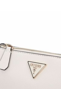 Clutch bianco con texture, zip in tonalità oro e accento con logo a triangolo. Presenta un motivo sottile e una linguetta per un'apertura facile.