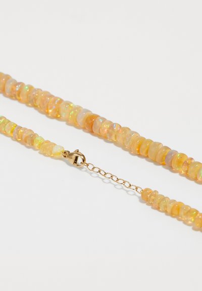 Opalperlennkette mit orange- und gelbtönen, versehen mit einem goldenen Verschluss und einer Verlängerungskette. Glatte, runde Perlen mit schillerndem Glanz.