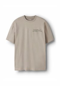 Beige bomulls-t-shirt med korta ärmar. Har svart text: "Porte d’Auteuil" och koordinater. Mjuk textur, rund halsringning.