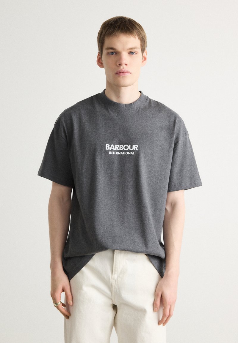 Szara bawełniana koszulka z okrągłym dekoltem i krótkimi rękawami, z białym logo "BARBOUR INTERNATIONAL" na piersi.