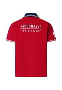 Polo rojo con cuello azul marino, rayas blancas en las mangas y texto blanco "FAÇONNABLE CÔTE D'AZUR" en la espalda.