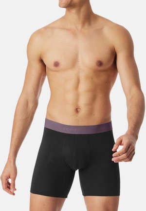 Schwarze Boxershorts mit einem violetten Bund, der das "SCHIESSER"-Logo trägt, aus einem glatten, dehnbaren Material für Komfort und Passform.