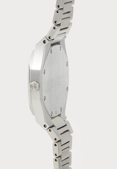 Orologio in acciaio inox argentato con cassa ottagonale, fondo testurizzato e bracciale in metallo a maglie, caratterizzato da viti visibili e accenti lucidi.