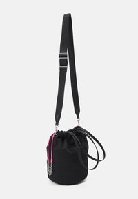 Sac à dos noir avec accents roses, fait de matériaux doux. Comprend une sangle ajustable, un détail de chaîne et une forme arrondie.