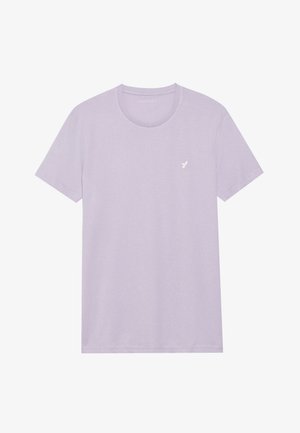 Šviesiai violetinė trumpomis rankovėmis marškinėliai, apvaliu kaklu, pagaminti iš minkštos medžiagos. Kairėje krūtinės pusėje yra mažas baltas logotipas. Paprastas dizainas.