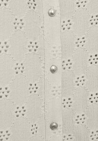 Witte button-up shirt van textuurstof met geborduurde patronen. Zilveren knopen accentueren de knoopsluiting met een lichtgewicht, ademend ontwerp.