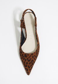 Pointed-toe shoe with a brown suede upper featuring a black leopard print. Slingback strap, open sides, and a beige insole.