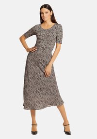 Leopardenmuster Midi-Kleid aus leichtem Stoff, mit kurzen Ärmeln, Rundhalsausschnitt und fließendem Saum. Betont mit einer taillierten Taille.