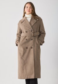 Bruine wolmix jas met een dubbelbreasted ontwerp, grote revers, een ceintuur in de taille en zijzakken. Soepele textuur met donkere knopen.
