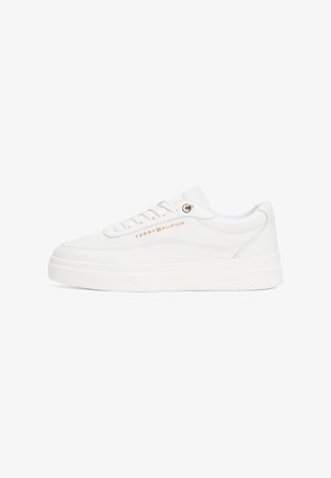 White leather sneaker with a padded collar, flat laces, and a textured rubber outsole. Features gold brand logo on the side.