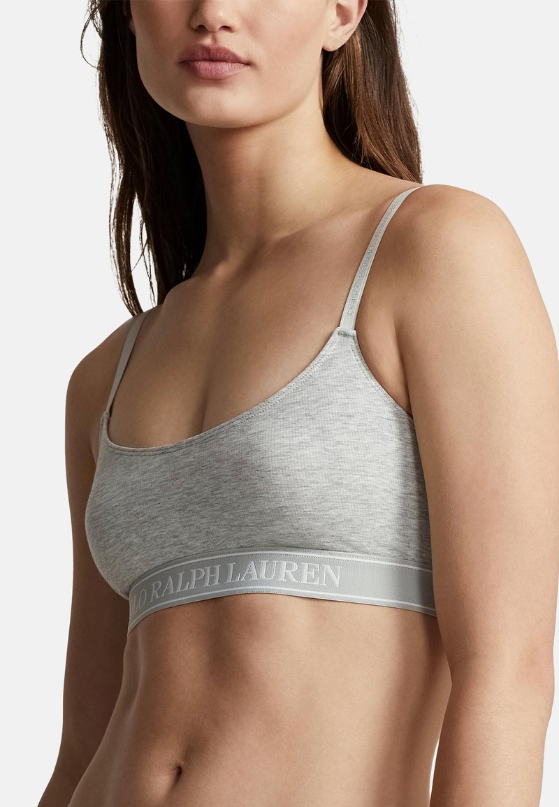 Bralette de algodón gris claro con tirantes delgados ajustables y una amplia banda elástica con el logo "Ralph Lauren". Textura suave, diseño simple.