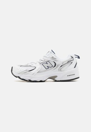 Weiße Sportschuhe mit einem Obermaterial aus Mesh, grauen Akzenten und einer gepolsterten Sohle. Enthält ein hervorgehobenes "N"-Logo und strukturierte Details an der Seite.